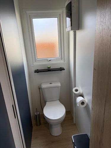 a small bathroom with a toilet and a window at Finca Leberto in Renesse