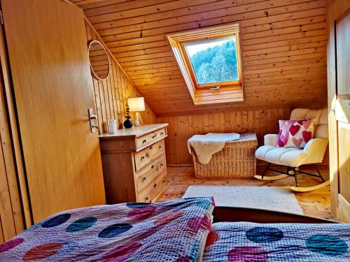 a bedroom with a bed and a chair in a cabin at Haus Sommerseit'n Ruhe-Natur-Genuss in Hirschbach