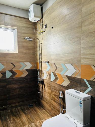 a bathroom with a toilet and a wall with geometric patterns at Viora Lodge in Nuwara Eliya