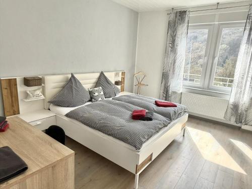 a bedroom with a bed and a desk and windows at Schöne Aussicht in Ediger-Eller
