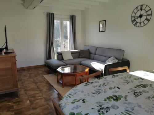 a living room with a couch and a table at Maisonnette au calme in Sully-sur-Loire