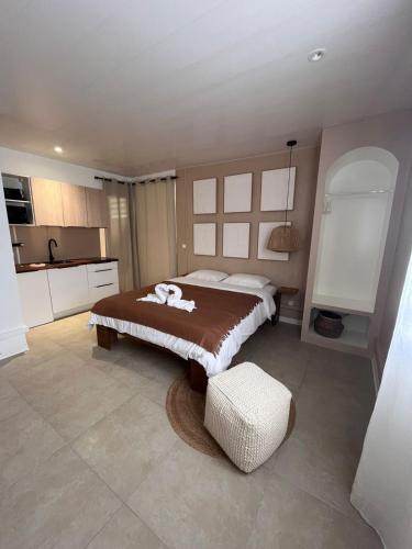 a bedroom with a large bed and a kitchen at Studio Tulum - jacuzzi privé - face à la mer in Tartane