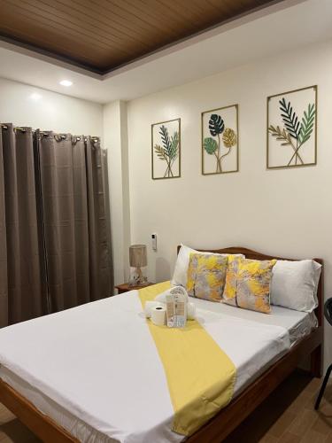 a bedroom with a bed with a yellow blanket on it at Escubin Travellers Inn in San Miguel