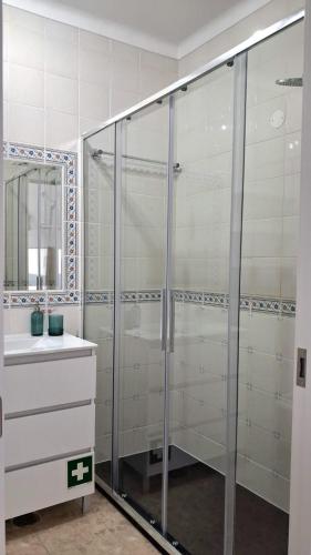 a bathroom with a glass shower and a sink at Da Rocha Beach 8, SEA VIEW in Portimão