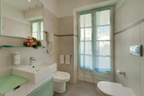 a white bathroom with a sink and a toilet at Appartamenti - Villa Mare in Pomonte