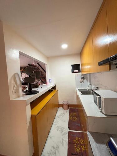 a small kitchen with a sink and a microwave at Amalia Homes Staycation in Palo