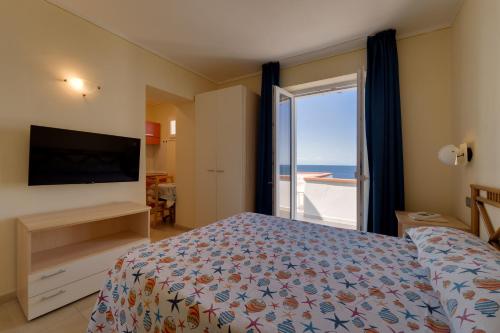 a bedroom with a bed and a window with the ocean at Appartamenti - Villa Mare in Pomonte