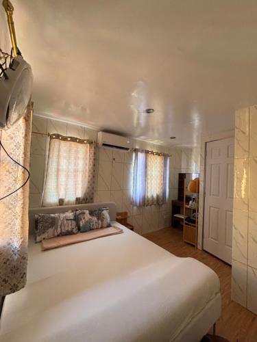 a bedroom with a large white bed and curtains at Amalia Homes Staycation in Palo
