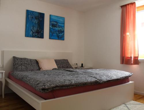 a bedroom with a bed with three pictures on the wall at Panorama Latemar in Nova Levante