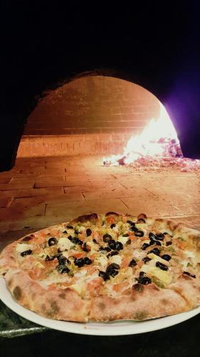 a pizza on a plate in a pizza oven at Relais Il Mulino in Corigliano Calabro