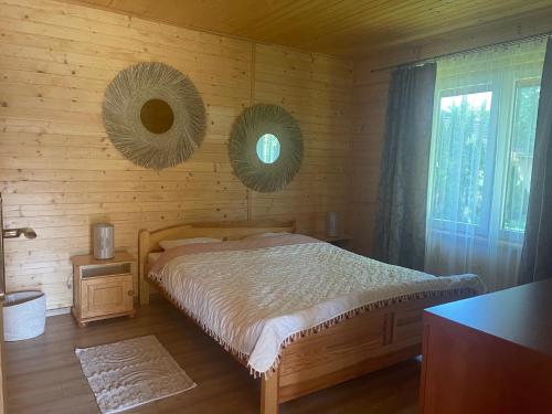 a bedroom with a bed and two mirrors on the wall at Domki Alex in Dębki