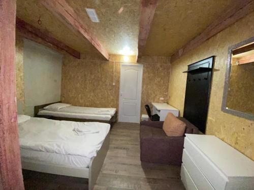 a small room with two beds and a couch at Attic rooms-Bēniņu istabas in Jelgava