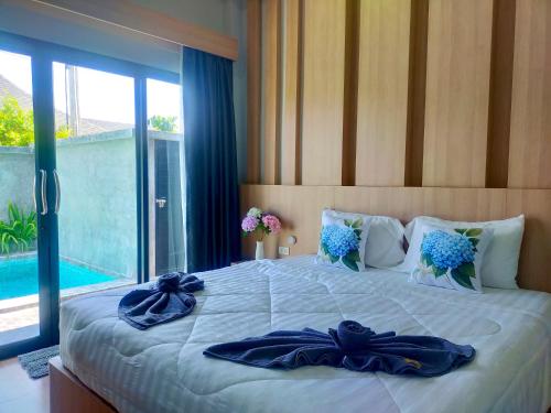 a bedroom with a large bed with blue flowers on it at Aonang Homie Pool villa in Ao Nang 