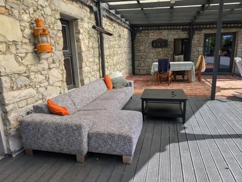 a couch sitting on a patio with a table at Woodville Barn in Ród