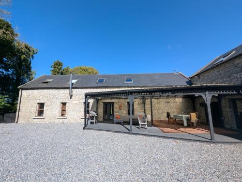 a large brick building with a patio in front of it at Woodville Barn in Ród