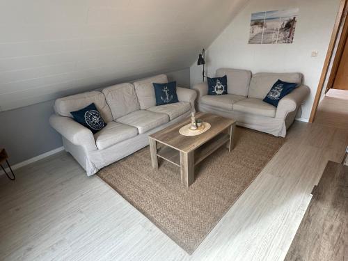 a living room with a couch and a table at Rosenhaus Esens - Wohnung Backbord in Esens