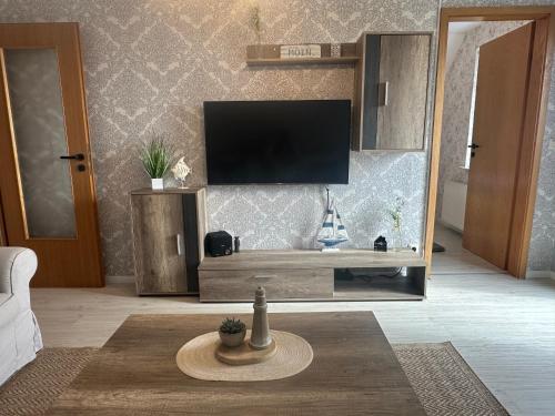 a living room with a flat screen tv on a wall at Rosenhaus Esens - Wohnung Backbord in Esens