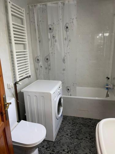a bathroom with a toilet and a tub and a washing machine at Large and cozy studio in Piera