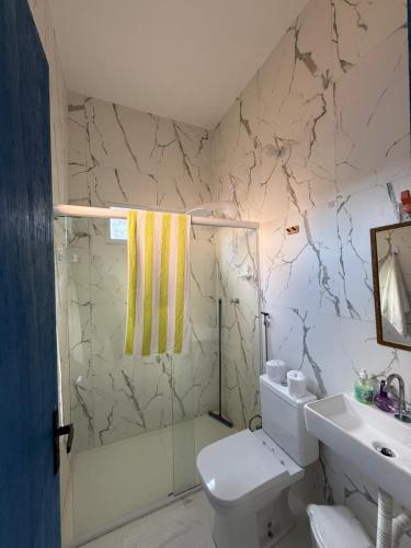 a bathroom with a white toilet and a sink at Apartamentos e Casas em Barra do Cunhaú in Canguaretama