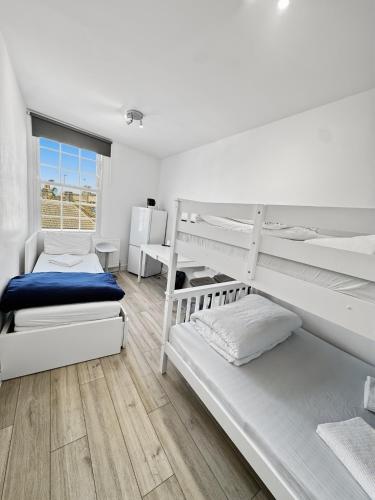 a bedroom with two bunk beds and a window at Room for 5 in Zone 2 - Willesden Green in London