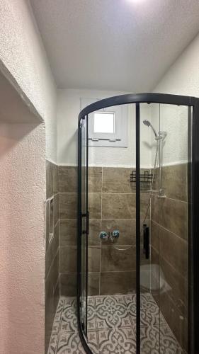 a shower with a glass door in a bathroom at Pergamon Yunt Evleri in Bergama