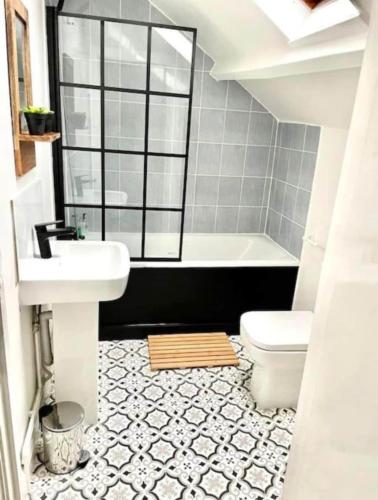 a bathroom with a sink and a tub and a toilet at Central location location in Hollington