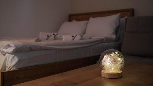 a bed with white sheets and a bowl of flowers on a table at Hop Kop in Kopaonik
