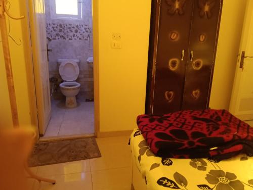 a bathroom with a toilet and a bed in a room at فندق سيتي ابيدوس in Abydos