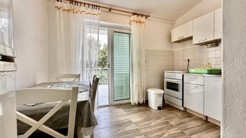 a small kitchen with a table and a window at Arbium Classic in Rab