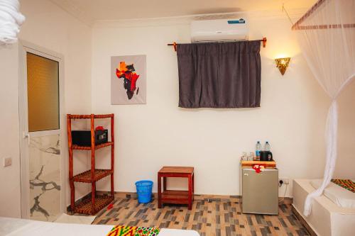 a room with a small refrigerator and a window at Karibu House Paje in Paje