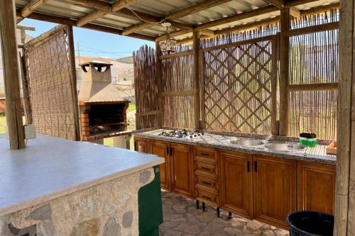 an outdoor kitchen with wooden cabinets and an outdoor oven at Villa 365 in La Rábita