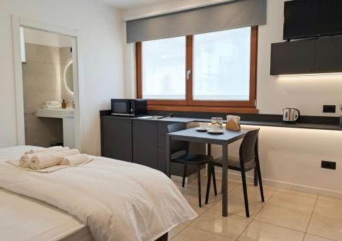 a room with a bed and a table and a kitchen at GUEST ROOM GRADONOVE in Arco