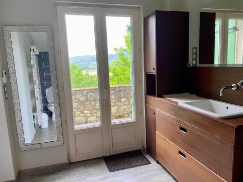 a bathroom with a sink and a door with a window at Le chant des Loriots in Bajamont