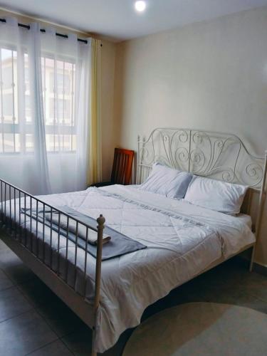 a bedroom with a large bed with white sheets at Peaceful Paradise in Gatunga