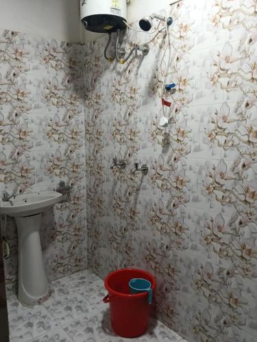 a bathroom with a shower with a sink and a bucket at Sai Palace in Darjeeling
