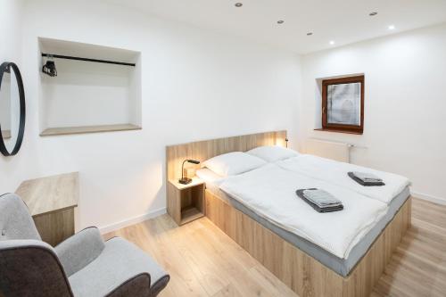 a bedroom with a bed and two chairs at Centrum Comfort Apartment in Rimavská Sobota