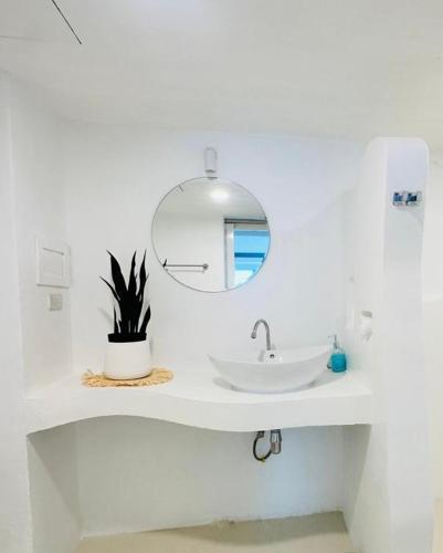 ein weißes Badezimmer mit Waschbecken und Spiegel in der Unterkunft SOLEA Beach in Nathon Bay