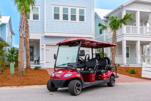 a golf cart parked in front of a house at Happily Eva After at Prominence 30A in Inlet Beach