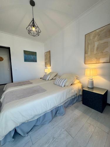 a bedroom with a large bed with two pillows at MHouse lease Cascais Spacious 3 BR Family next center in Alcabideche
