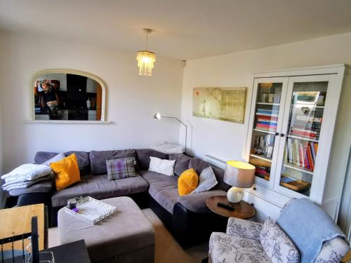 a living room with a couch and a table at Cozy Cotswold getaway near Burford in Shilton