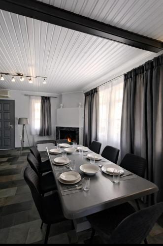 a large dining room table with chairs and a fireplace at Green Garden Private Villa in Porto Heli