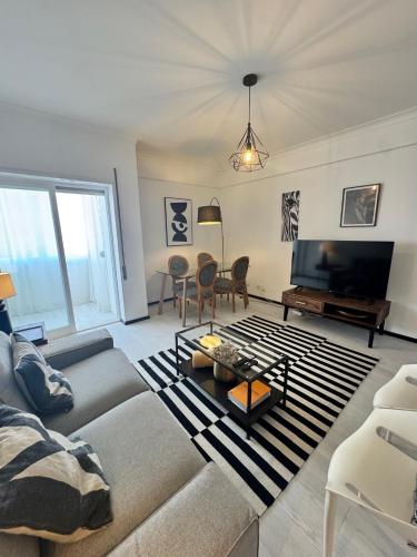 a living room with a couch and a tv at MHouse lease Cascais Spacious 3 BR Family next center in Alcabideche