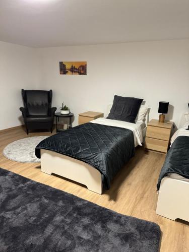 a bedroom with two beds and a chair at Studio apartment in Karben