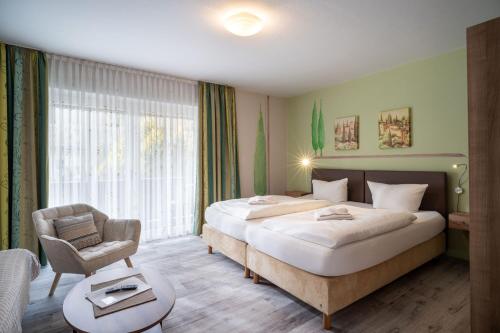 a hotel room with a large bed and a chair at Frühstückspension Lavendel in Oberaudorf