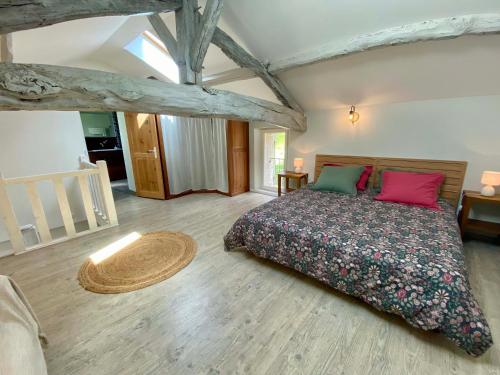 a bedroom with a bed and a wooden floor at Le chant des Loriots in Bajamont