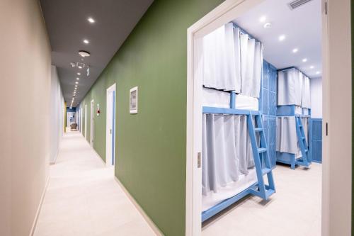korytarz szpitala z zielonymi ścianami i drabiną w obiekcie Mega Hostel w Sarandzie