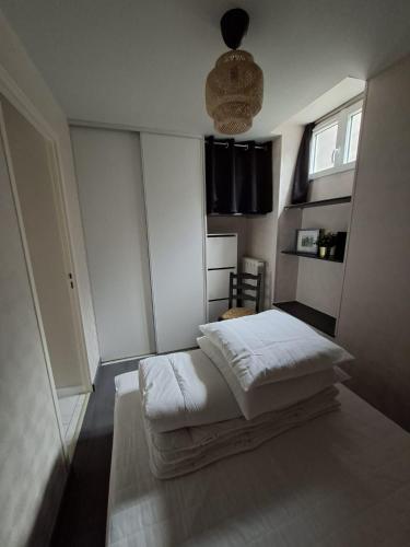 a bedroom with a bed with white sheets at Appartement Véronica - Villa Damary in La Bourboule