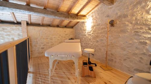 a white table in a room with a wall at Château Clos des Maurins in Vérac