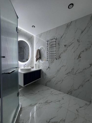 a white bathroom with a sink and a mirror at Alvina Private Yard Apartment in Tsaghkadzor