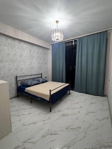 a bedroom with a bed in a room with a chandelier at Alvina Private Yard Apartment in Tsaghkadzor